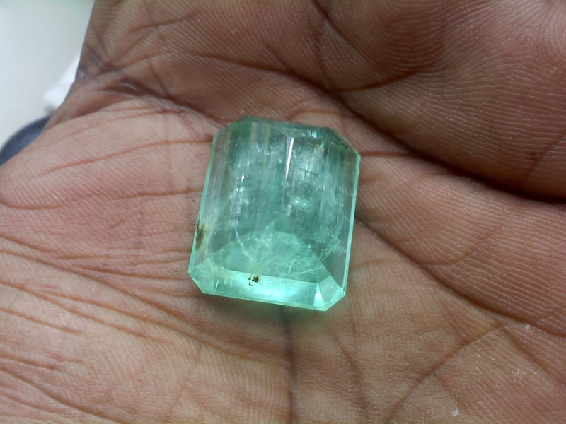 1.85 carat natural Zambian emerald, oval mixed cut, on white background