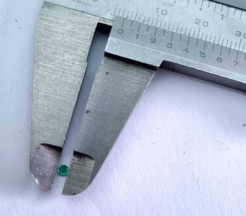 1.10 carat natural Brazilian emerald, round cut, on white background